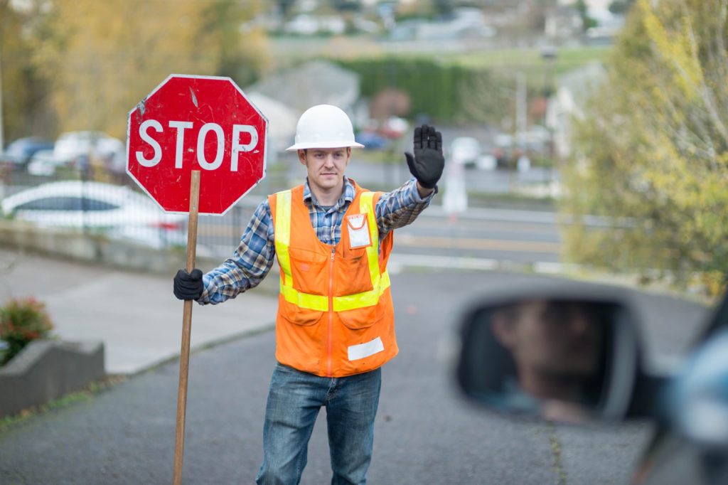 Construction worker telling cars to stop